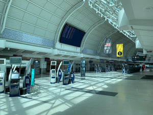 Interior of a large indoor facility with kiosks and digital displays.