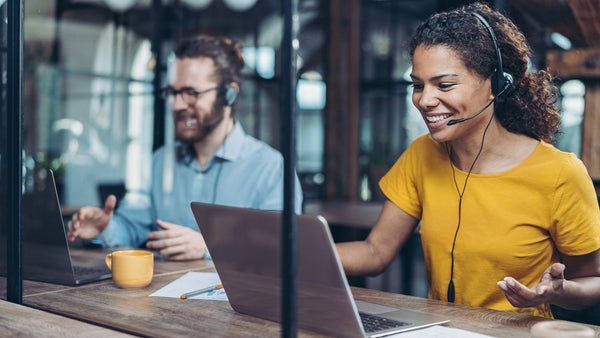 Man and woman doing virtual consulting with headsets.