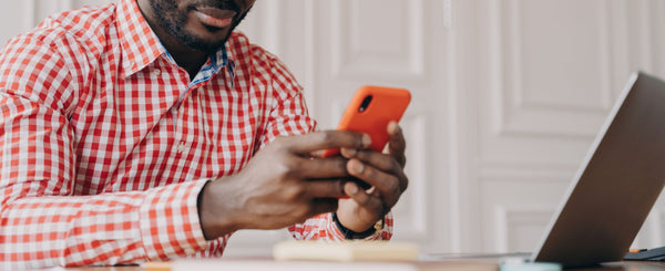 Man using phone to read alerts from security system.