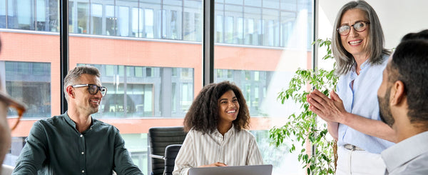 Team working in an office having a discussion and smiling.